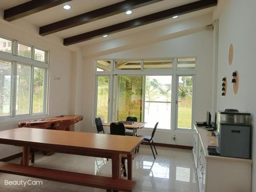 a dining room with tables and chairs and windows at Oh! Yosuw BnB in Chulu