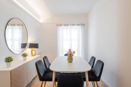 a white dining room with a white table and chairs at Milan Royal Suites - Centro in Milan