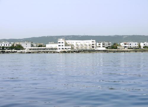 a large body of water with buildings in the background at Hotel La Sorgente in Savelletri di Fasano