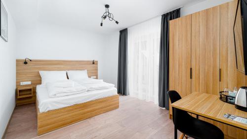 a bedroom with a bed and a desk and a table at Emilly Center in Karpacz