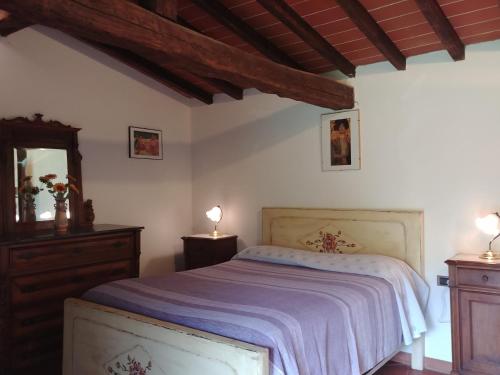 1 dormitorio con cama, tocador y espejo en Agriturismo Botro, en Pulicciano