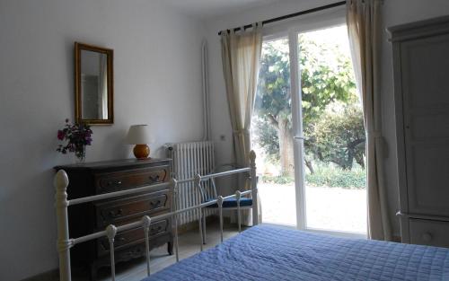 une chambre avec un lit et une porte coulissante en verre dans l'établissement Gite de tournon, à Montauroux