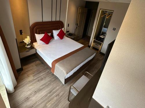 a bedroom with a large bed with red pillows at Edition Old City Hotel in Istanbul