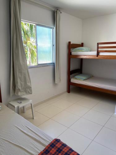 a bedroom with a bunk bed and a window at apartamento de frente para o mar in Vera Cruz de Itaparica