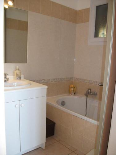 une salle de bain avec un lavabo et une baignoire dans l'établissement Mas longo mai avec piscine, à Vidauban