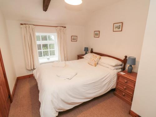 a bedroom with a large white bed and a window at The Cottage in Pickering