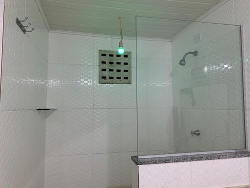 ein Bad mit einer Dusche und einer Glaswand in der Unterkunft apartamento de frente para o mar in Vera Cruz de Itaparica