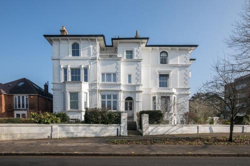 une grande maison blanche avec une clôture devant elle dans l'établissement Riverside 2 Bedroom Central Kingston Flat, à Kingston upon Thames