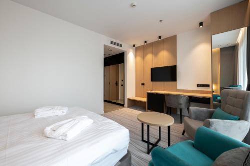 a hotel room with a bed and a table and chairs at The Grandeur Hotel in Batumi