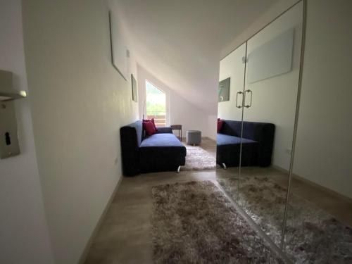 a living room with a couch and a glass door at Appartement Vogelkoje Nummer 35 in Baiersbronn
