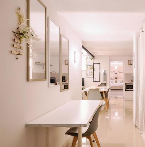 une salle à manger blanche avec une table et des chaises dans l'établissement vélodrome F4 dans villa 5 lits parking et piscine partagee, à Marseille