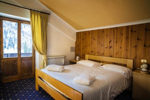 een slaapkamer met een bed met twee handdoeken erop bij Hotel Monzoni - San Pellegrino in Passo San Pellegrino