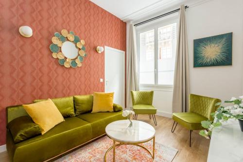 ein Wohnzimmer mit einem grünen Sofa und 2 Stühlen in der Unterkunft Cosy 3 bedroom and 2 Bathroom - Opera in Paris