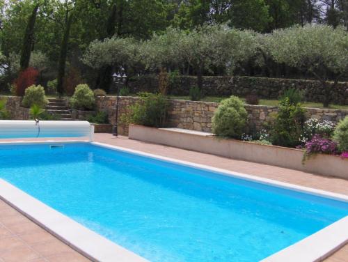 une piscine dans un jardin avec un mur de retenue dans l'établissement La picholine, à Draguignan
