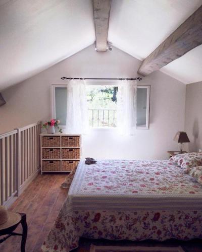 une chambre avec un grand lit et une fenêtre dans l'établissement La picholine, à Draguignan