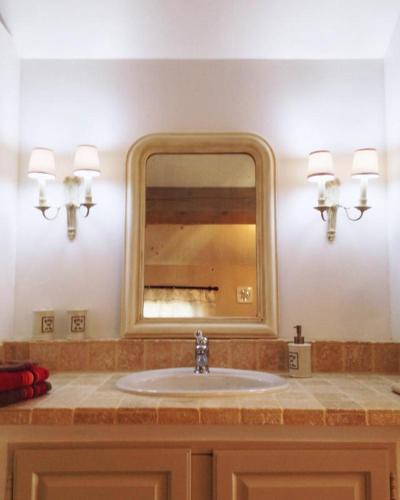 une salle de bain avec un lavabo et un miroir dans l'établissement La picholine, à Draguignan