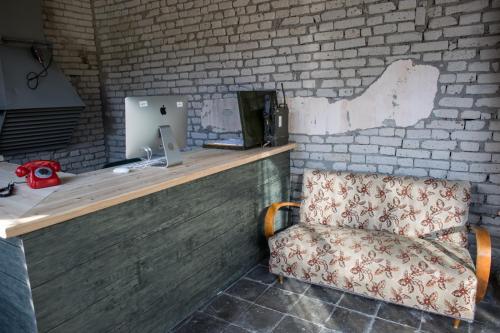 a desk with a chair next to a brick wall at Kazerma e Cerenit in Surreli