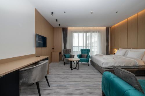a hotel room with a bed and a tv at The Grandeur Hotel in Batumi