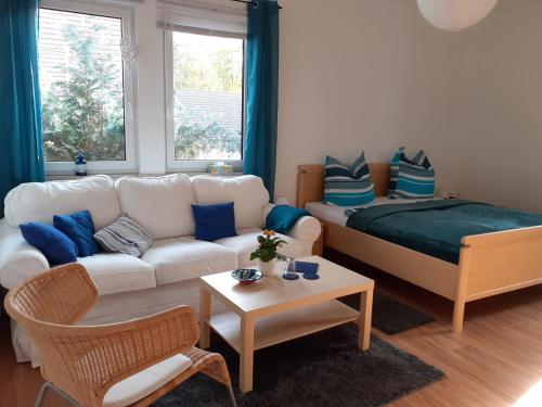 a living room with a white couch and blue pillows at Villa Tannerhof in Braunlage