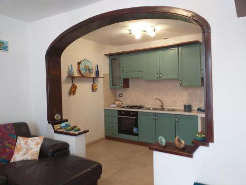 - une cuisine avec des placards verts et un canapé dans la chambre dans l'établissement BeachFront House - Sant'Angelo Ischia, à Ischia