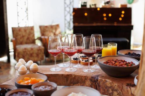 a table topped with glasses of wine and bowls of food at Kazerma e Cerenit in Surrel