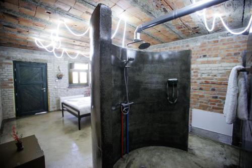 a bathroom with a shower in a brick wall at Kazerma e Cerenit in Surreli
