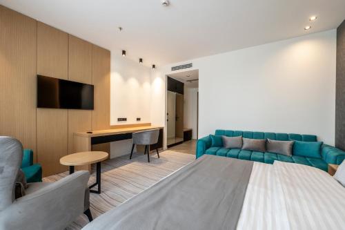 a hotel room with a bed and a couch and a desk at The Grandeur Hotel in Batumi