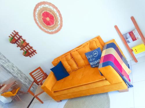 a living room with a yellow couch and a chair at Casa Arembepe in Camaçari