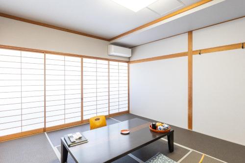 a room with a table and some windows at Yoshino in Ito