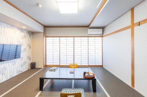 a room with a table and a large window at Yoshino in Ito