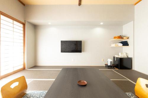 a living room with a wooden table and orange chairs at Yoshino in Ito