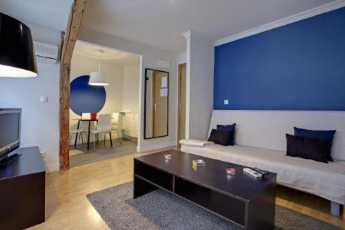 sala de estar con sofá y pared azul en Hostal Santa Ana Colors, en Madrid