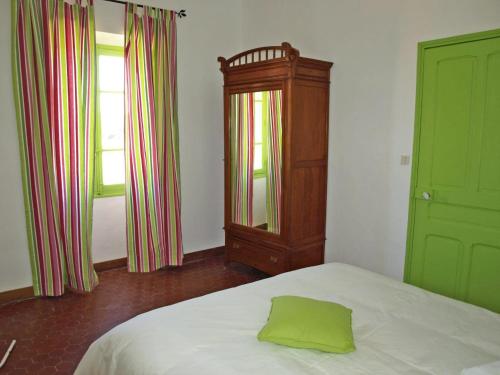 - une chambre dotée d'un lit avec un oreiller vert dans l'établissement Bassegat nature, à Fox-Amphoux