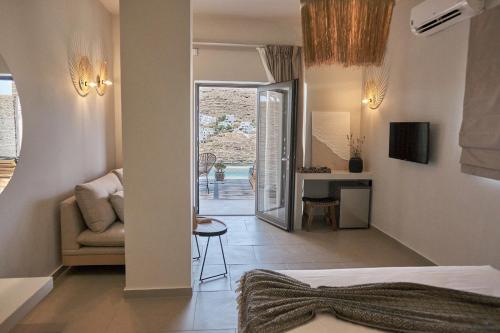 a hotel room with a bed and a living room at Amal Kythnos Suites in Kithnos