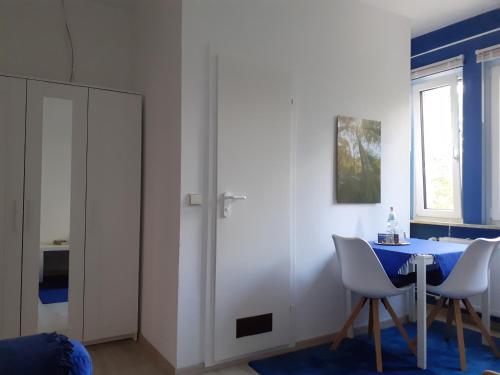 a dining room with a blue table and white chairs at Villa Tannerhof in Braunlage