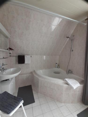 a bathroom with a bath tub and a sink at Villa Tannerhof in Braunlage