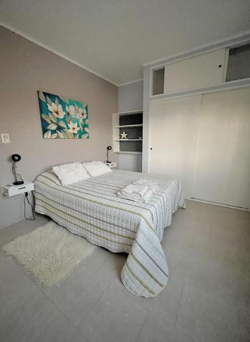 a bedroom with a bed with a blanket and a table at Pueblo Nuevo in Junín