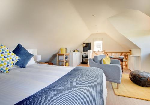 a bedroom with a large bed and a kitchen at Swift Lodge in Kirton