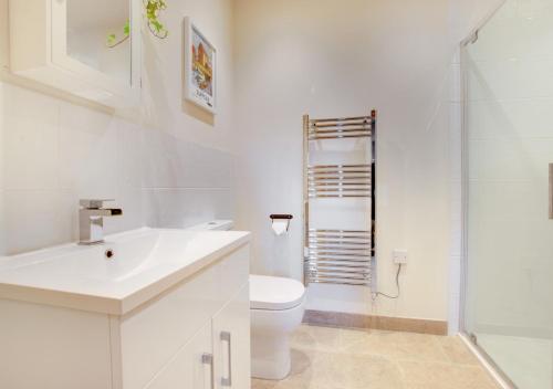 a white bathroom with a sink and a toilet at Swift Lodge in Kirton
