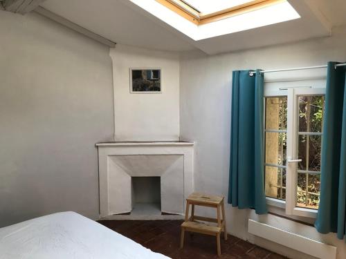 - une chambre avec un lit, une cheminée et une fenêtre dans l'établissement Le mas du castellanet, à Taradeau