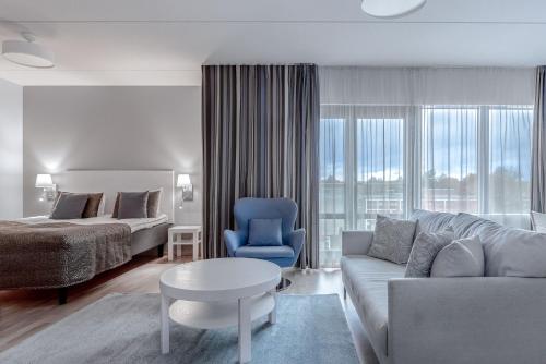 een woonkamer met een bank, een bed en een tafel bij Holiday Club Caribia Superior Apartments in Turku