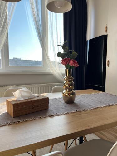 a table with a vase with roses and a box on it at Urbanna Premium - private parking included in Arad