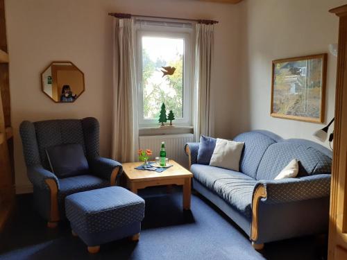 a living room with a couch and two chairs and a table at Villa Tannerhof in Braunlage