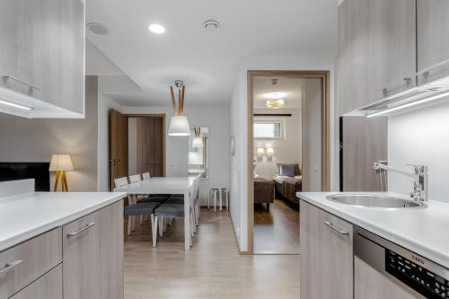 a kitchen with a sink and a dining room at Holiday Club Caribia Superior Apartments in Turku