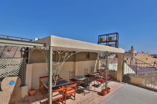 Tienda en la azotea de un edificio con mesas y sillas en Riad Fez Unique, en Fez