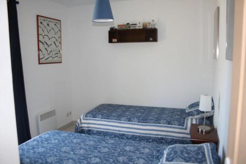 - 2 lits dans une petite chambre avec des draps bleus dans l'établissement Les restanques, à Saint-Maximin-la-Sainte-Baume