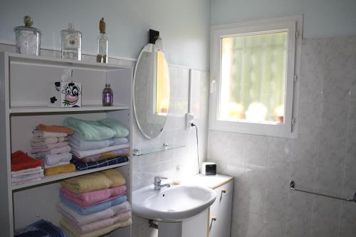 une salle de bain avec un lavabo, un miroir et des serviettes dans l'établissement Les restanques, à Saint-Maximin-la-Sainte-Baume