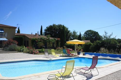 une piscine avec des chaises et un parasol dans l'établissement Les restanques, à Saint-Maximin-la-Sainte-Baume