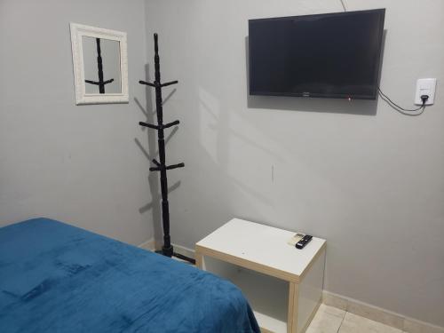 a bedroom with a bed and a tv on a wall at Hotel Ouro Preto in João Pessoa