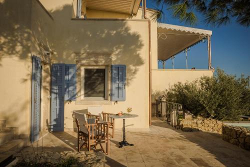 a patio with a table and chairs on the side of a house at Villa Comi in Mavráta